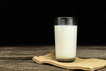 Milk on sack with a wooden table on dark background. Healthy food. Food and drink concept. Diet, Health.
