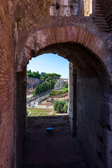 Vista del foro romano y palatino desde el coliseo, a través de uno de los arcos. Turistas paseando - obrazy, fototapety, plakaty