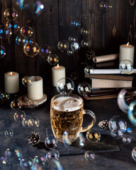 Pint of magic beer and candles on a dark bar counter