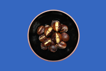 Baked chestnuts on black background.
Roasted chestnuts