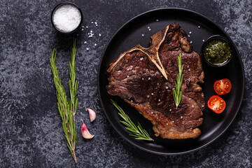 Grilled beef steak with spices on a black plate
