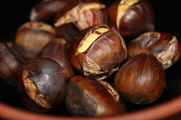 Baked chestnuts on black background.
Roasted chestnuts