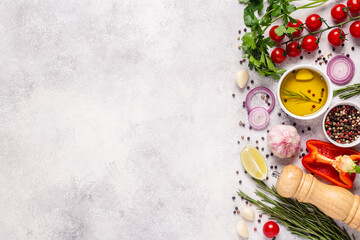 Herbs and condiments on light stone background.