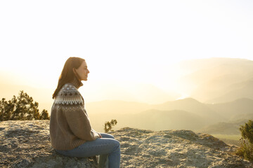 Casual woman in the top of a cliff contemplating in winter