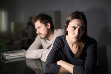Angry couple ignoring each other at home in the night
