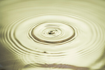 Close up view of drops making circles on water surface isolated on background.