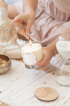 meditation space with candles and woman in lighting up a candle in the background