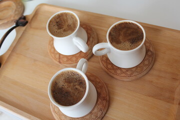Three cups of Turkish coffee on a wooden bamboo tray.
Mortar brown in white cups