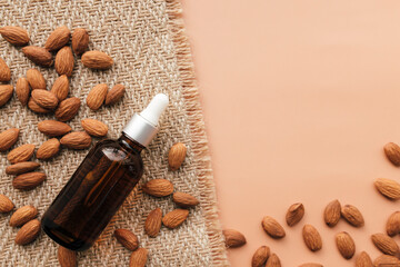 Almond essential oil in glass bottle, raw almond kernels. Cosmetic concept
