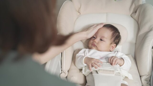 asian woman mother gently touching baby infant head with care lull to sleep on baby buggy at home. baby sleeping on baby stroller. natural authentic.
