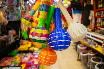 Colorful handmade rattles hanging inside a Mexican market