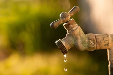 Fotobehang Exterior dripping water faucet or tap in yard © Scope Images