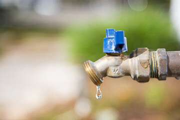 Exterior dripping water faucet or tap in yard