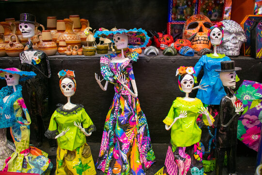 Colorful handmade skeleton figures displayed on black surface