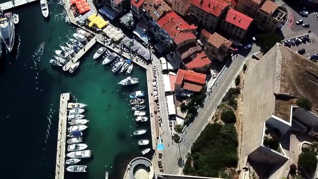 Citadel and town of Calvi with port, mountains and Mediterranean Sea, Corsica France. Drone flies over the city.