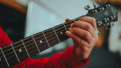 a man plays a guitar while pinching a chord