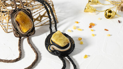 Beautiful old leather pendants-amulets with Baltic amber stone  on a white background. Isolated...
