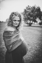 Close up image of a pregnant woman in a beautiful green dress in nature