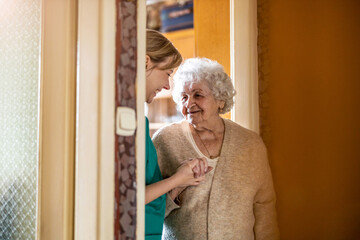 Female nurse taking care of a senior woman at home
