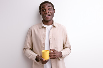 Smiling black guy with cup of coffee in the morning