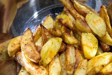 Crispy oven-baked potatoes. Delicious potatoes with herbs for dinner just out of the oven. Close up. 