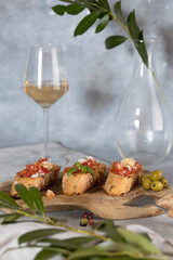 Homemade Italian Bruschetta Appetizer with Basil ,Tomatoes , parmesan ,olivien and glass of rose wine .
 Mediterranean Kitchen