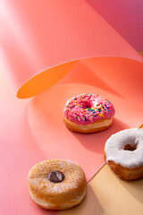 Mix of donuts on pink and caramel swirled background
