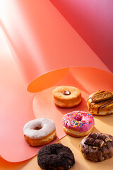 Mix of donuts on pink and caramel swirled background