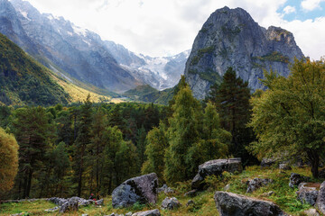 Fototapeta na wymiar A tourist surrounded by an autumn mountain range. Ossetia Tsey