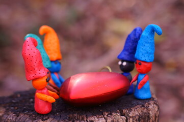 Figures of colorful gnomes with a toy heart.