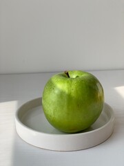 green apple on a golden background as an example of healthy food