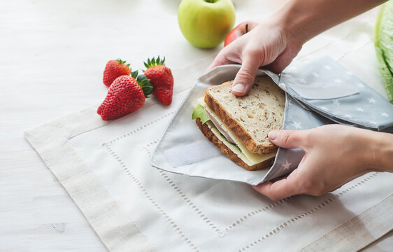 Person Hands Wrapping Whole Grain Sandwich Wrapped In Reusable Bag. Zero Waste Ecologic Concept