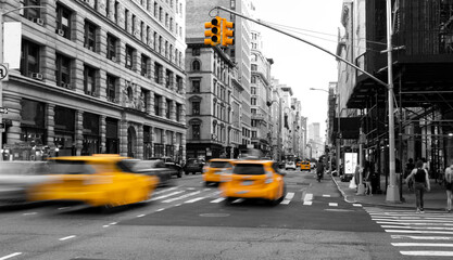 Yellow taxis driving down the street isolated on black and white view of New York City NYC