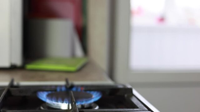 Male Hand Lighting The Fire At The Gas Stove And Putting A Frying Pan