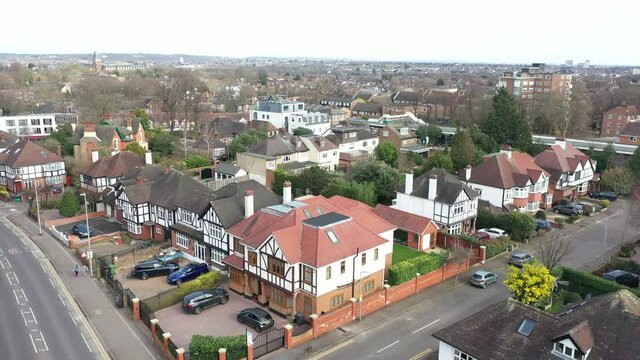 TWO WOMEN WALKING INFRON A BEAUTIFUL RESIDENCIAL AREA DRONE VIEW