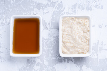 Fish sauce in white bowl and white sauce on gray cement background