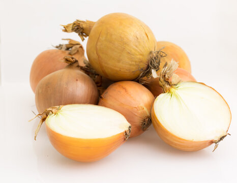 Cebule ułożone w stos, całe i przekrojone na p&oacute;ł