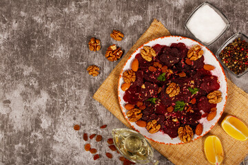 Beetroot Salad with raisins nuts and lemon on a dark gray background. Close-up.  Healthy eating, vegetarian food.