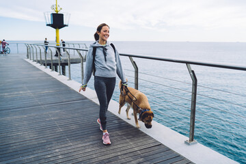 Active young woman with dog walking on promenade © BullRun