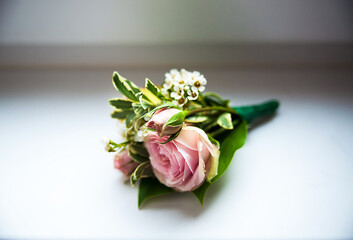 Close up of handmade wedding floral accessory. Decoration for hands or buttonhole. Isolated over white