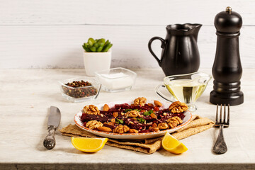 Beetroot salad with nuts raisins and lemon on light gray background. Close-up.  Healthy eating, vegetarian food.