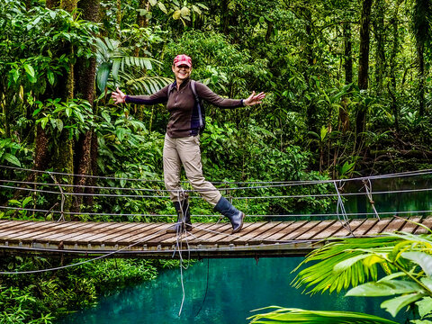 Tourist walks over a suspension bridge in Tenorio Volcano National Park, Costa Rica.
