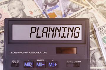 On the table are dollars and a calculator on the electronic board which says PLANNING