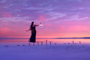 Fototapeta premium Girl Looking Out to Sea Holding Lantern