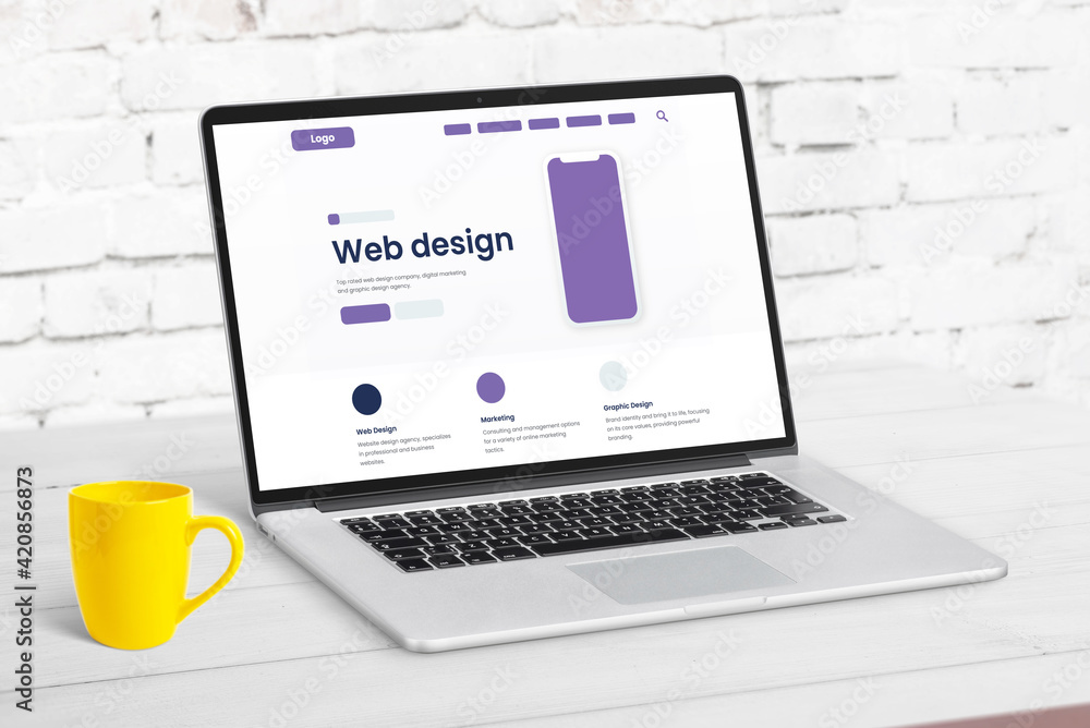 Aufkleber Web design studio page concept with website elements on laptop computer. Clean desk with yellow coffee mug beside