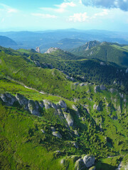 Aerial drone vertical panorama of Ciucas Mountains crests. On the alpine grasslands, eroded calcareous boulders are forming interesting stone conglomerations. Carpathia, Romania. 