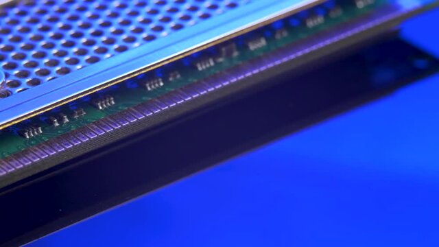 Memory module for PC with contact pins on blue light mirror surface. Heat spreader transfer energy to heat sink or exchanger. Computer hardware concept. Double data rate random access memory