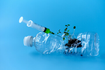  Used plastic bottle with plant sprouts. A syringe of medicine will be inserted into the bottle....