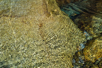 Clear water background.River stream. Big stone under clear water of river.Water background.Summer.