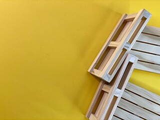 Wooden pallets are lying on a yellow background © Józef